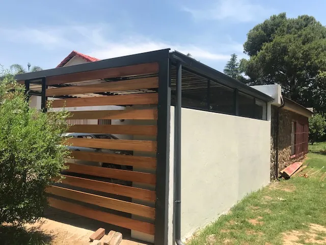 Steel carport with horizontal hardwood timber screen